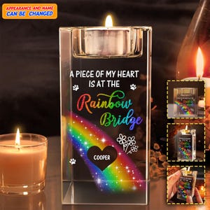 Może przedstawiać: Przezroczysty szklany świecznik ze świeczką typu tealight. Uchwyt zawiera napis "A PIECE OF MY HEART IS AT THE Rainbow Bridge" z tęczową grafiką i imieniem "COOPER" w sercu.
