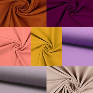May include: A collection of six fabric swatches in different colors, including brown, purple, pink, yellow, gray, and beige. The fabric is a soft, stretchy knit material.