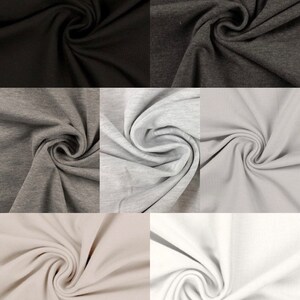 May include: Six fabric swatches in different colors: black, dark gray, light gray, beige, and white. The fabric is folded and twisted to show its texture.