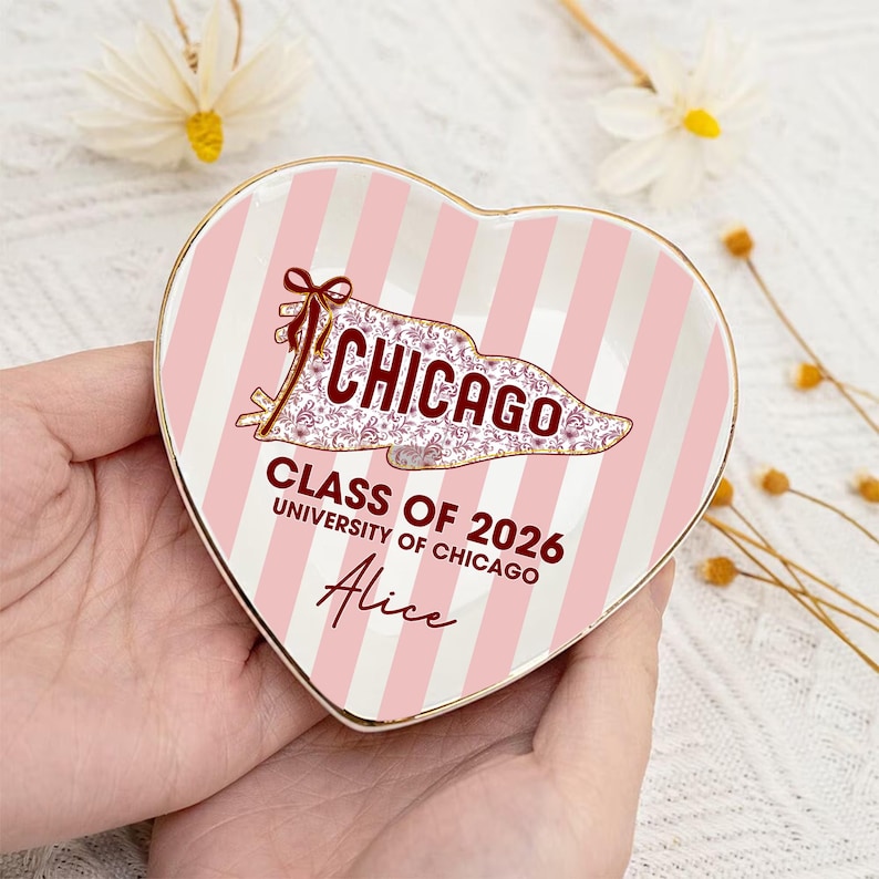 Puede incluir: Plato para baratijas en forma de coraz&oacute;n con rayas rosas y blancas. El plato presenta la palabra "CHICAGO" en un dise&ntilde;o estilizado, junto con "CLASS OF 2026 UNIVERSITY OF CHICAGO" y el nombre "Alice". El plato tiene un borde dorado.