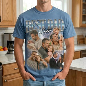 May include: A light blue t-shirt with the text "BEST DAD Ever" in silver lettering. The shirt features a collage of images of a father with his children. The images are in a variety of poses and settings.