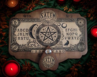 May include: Wooden Salem Ouija board with a planchette. The board features the alphabet, numbers, and the words "Yes" and "No." The design includes a crescent moon, a cat, a raven, and a pentagram. The planchette has the word "Salem" on it.