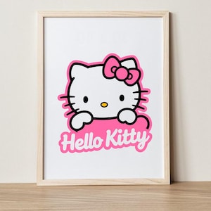 May include: Framed print featuring the iconic Hello Kitty character. The image shows Hello Kitty's white face with a pink bow, black eyes, and whiskers. The words "Hello Kitty" are in pink script below the character.