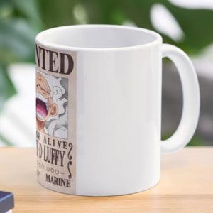 May include: White ceramic mug with a printed image of a wanted poster featuring a cartoon character with white hair and a large grin. The poster says "WANTED" and "DEAD OR ALIVE?" with a reward amount of 5,000,000,000. The poster also says "MARINE".