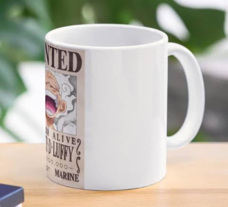 May include: White ceramic mug with a printed image of a wanted poster featuring a cartoon character with white hair and a large grin. The poster says "WANTED" and "DEAD OR ALIVE?" with a reward amount of 5,000,000,000. The poster also says "MARINE".