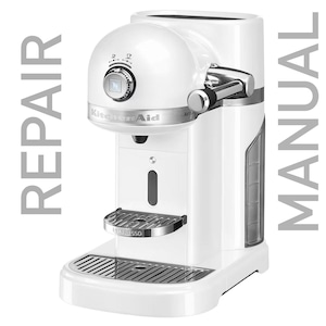 May include: White KitchenAid espresso machine with a chrome drip tray and a silver control knob. The machine has a water tank on the side and a removable drip tray.