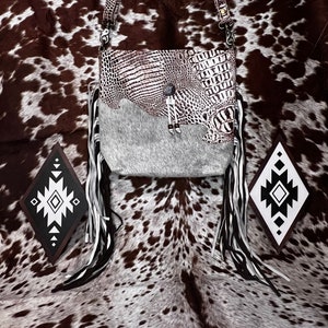 Cartera de piel de serpiente y pelo gris sobre piel de vaca