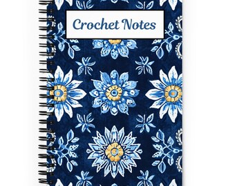 Pode incluir: Um caderno espiral azul e branco com padrão floral e o texto "Crochet Notes" na capa.