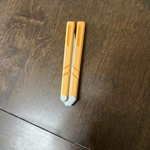 May include: A yellow metal folding knife with a silver handle.