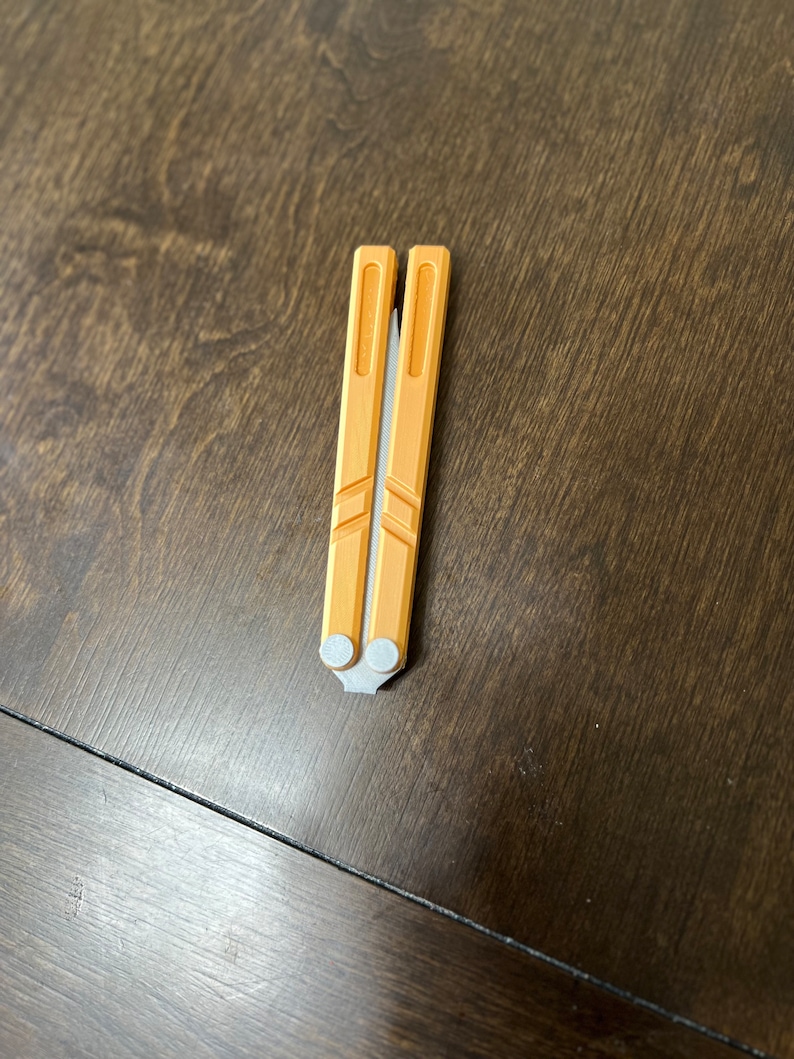 May include: A yellow metal folding knife with a silver handle.