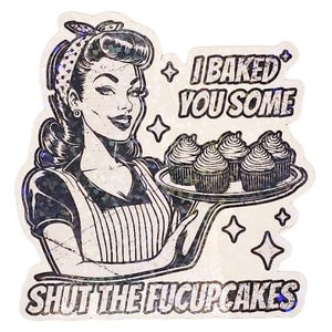 May include: A sticker featuring a retro-style illustration of a woman holding a tray of cupcakes. The text reads "I Baked You Some Shut the Fucupcakes". The design is in black and white with a glittery finish, evoking a vintage aesthetic.