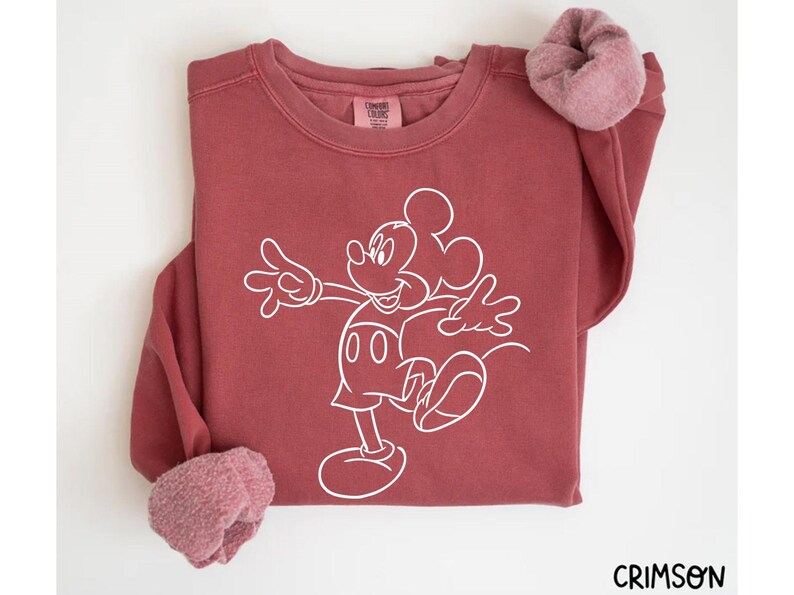 May include: A maroon sweatshirt with a white outline of Mickey Mouse on the front. The sweatshirt has a crew neck and long sleeves.