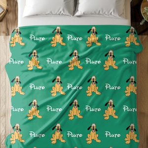 May include: A green blanket featuring a repeating pattern of the cartoon character Pluto in a sitting pose. The word "Pluto" is written in white script between each Pluto image. The blanket is on a bed with white pillows.