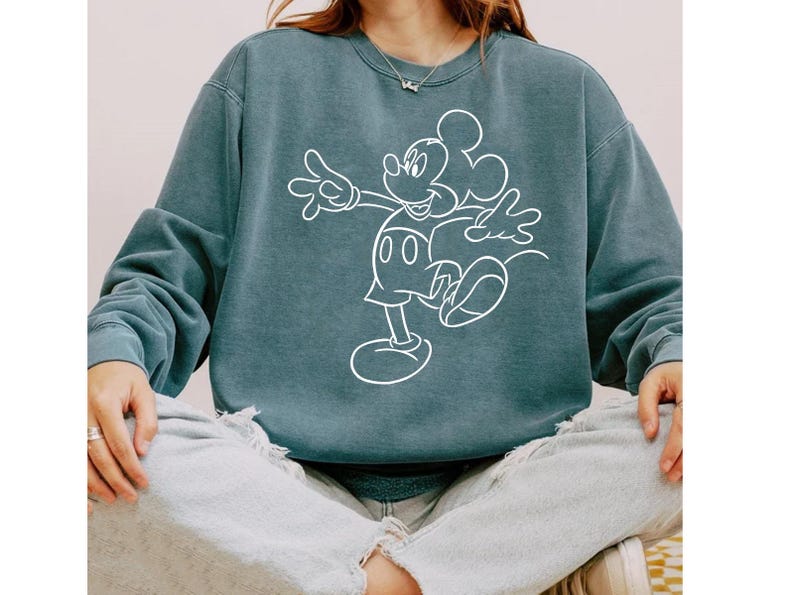 May include: A teal blue sweatshirt with a white outline of Mickey Mouse.