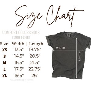 May include: A size chart for a Comfort Colors 9018 youth t-shirt. The chart lists sizes XS through XL with corresponding widths and lengths in inches. A dark grey t-shirt is shown with white arrows indicating where to measure width and length.