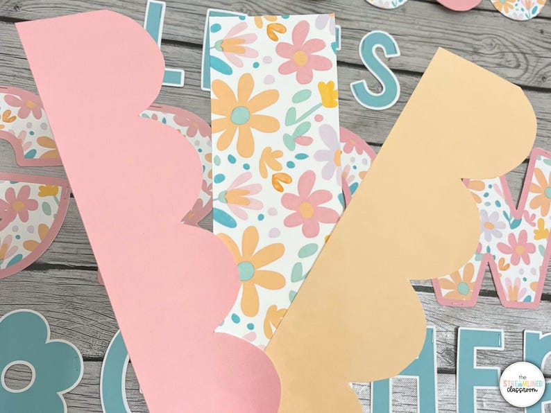 May include: Two scalloped paper borders in pink and peach with a floral pattern in the background. The floral pattern is white with pink, yellow, and blue flowers.