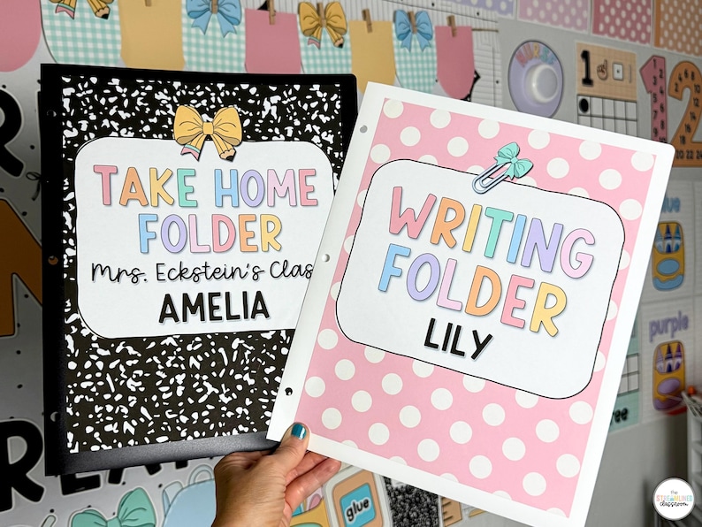 May include: Two school folders, one black with a white speckled design and the other pink with white polka dots. The black folder reads "TAKE HOME FOLDER" and the pink folder reads "WRITING FOLDER". Both have the student's name.