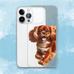 May include: A clear phone case with a brown and white Cavalier King Charles Spaniel peeking out from the side. The dog is looking to the right and has a happy expression.