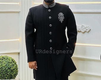 Könnte beinhalten: Eine schwarze, langärmelige Kurta mit Stehkragen und silberner Stickerei. Die Kurta hat ein langes, fließendes Design und wird mit einer schwarzen Hose getragen.