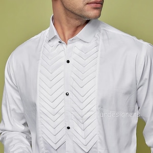 May include: A white long-sleeve dress shirt with a pleated front panel. The shirt has a classic collar and button closure.