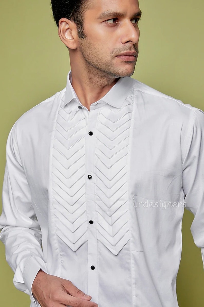 May include: A white long-sleeve dress shirt with a pleated front panel. The shirt has a classic collar and button closure.