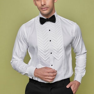 May include: A white dress shirt with a pleated front and a black bow tie. The shirt has a classic, formal look.