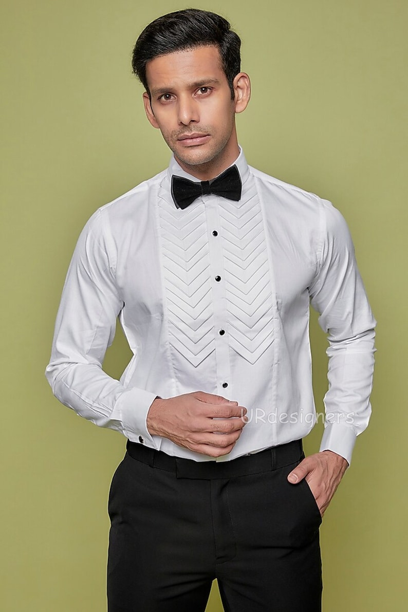 May include: A white dress shirt with a pleated front and a black bow tie. The shirt has a classic, formal look.
