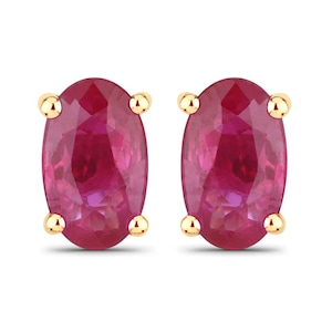 May include: A pair of oval-shaped ruby earrings set in gold.