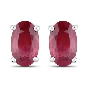 May include: A pair of oval-shaped ruby earrings set in silver.