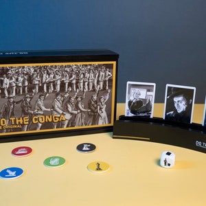 Op de afbeelding: Een zwart doos spel genaamd "Do the Conga: The Original" met een zwart-witte afbeelding van een conga-lijn op de voorkant. De doos is open en toont een zwart-witte kaarthouder met drie kaarten. De kaarten tonen zwart-witte afbeeldingen van mensen. Er zijn ook vijf kleurrijke tokens en een witte dobbelsteen met zwarte stippen.