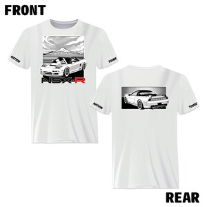 May include: White t-shirt with a black and white illustration of a Honda NSX-R on the front and back. The front design features the car driving up a mountain road with a mountain in the background. The back design features the car from the rear. The sleeves of the shirt have the words "NATION" and "TOUGE" printed on them.