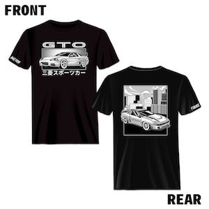 Pode incluir: Camiseta preta com um gráfico branco de um carro Mitsubishi GTO na frente. O texto "GTO" e "三菱スポーツカー" está impresso na frente. A parte de trás da camiseta apresenta um gráfico branco do carro dirigindo por uma cidade com o texto "TOUGE" na manga.