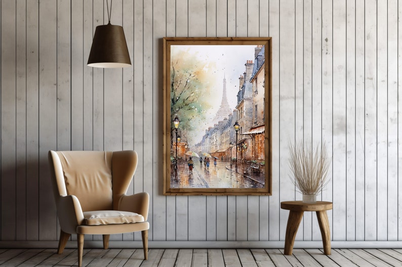 May include: A watercolor painting of a Parisian street scene with the Eiffel Tower in the distance. The painting is framed in a brown wooden frame and is hanging on a white wall.