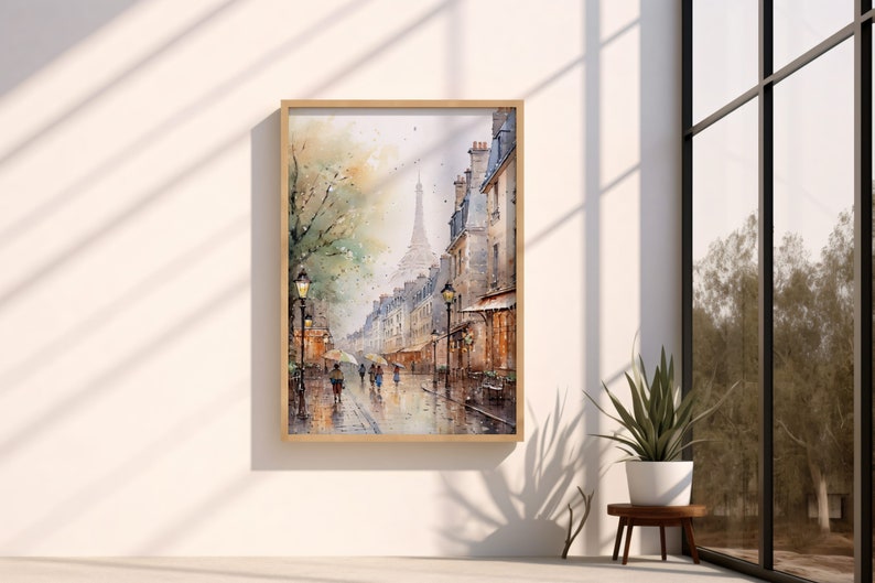 May include: A watercolor painting of a Parisian street scene with the Eiffel Tower in the distance. The street is lined with buildings and there are people walking on the sidewalk. The painting is framed in a light wood frame.