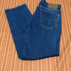 May include: A pair of blue denim jeans with a brown leather patch on the back pocket.