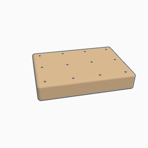 May include: A light brown rectangular block with a textured surface and multiple small holes.