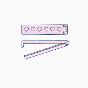 May include: A pink heart-shaped cookie cutter with a hinged handle. The cutter is open and ready to use.