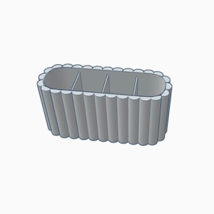 May include: A gray, rectangular, divided organizer with a wavy, textured exterior. The organizer has three compartments.