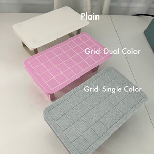 May include: Three table top designs: a plain white surface, a pink surface with a grid pattern, and a gray surface with a grid pattern. The text "Grid-Dual Color" is above the pink surface and the text "Grid-Single Color" is above the gray surface.