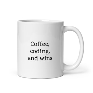 May include: White ceramic coffee mug with black text that reads "Coffee, coding, and wins".