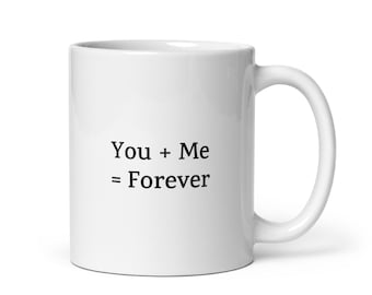 May include: White ceramic coffee mug with black text that reads "You + Me = Forever".