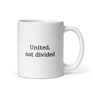 Puede incluir: Taza de café de cerámica blanca con el texto "United, not divided" impreso en negro.