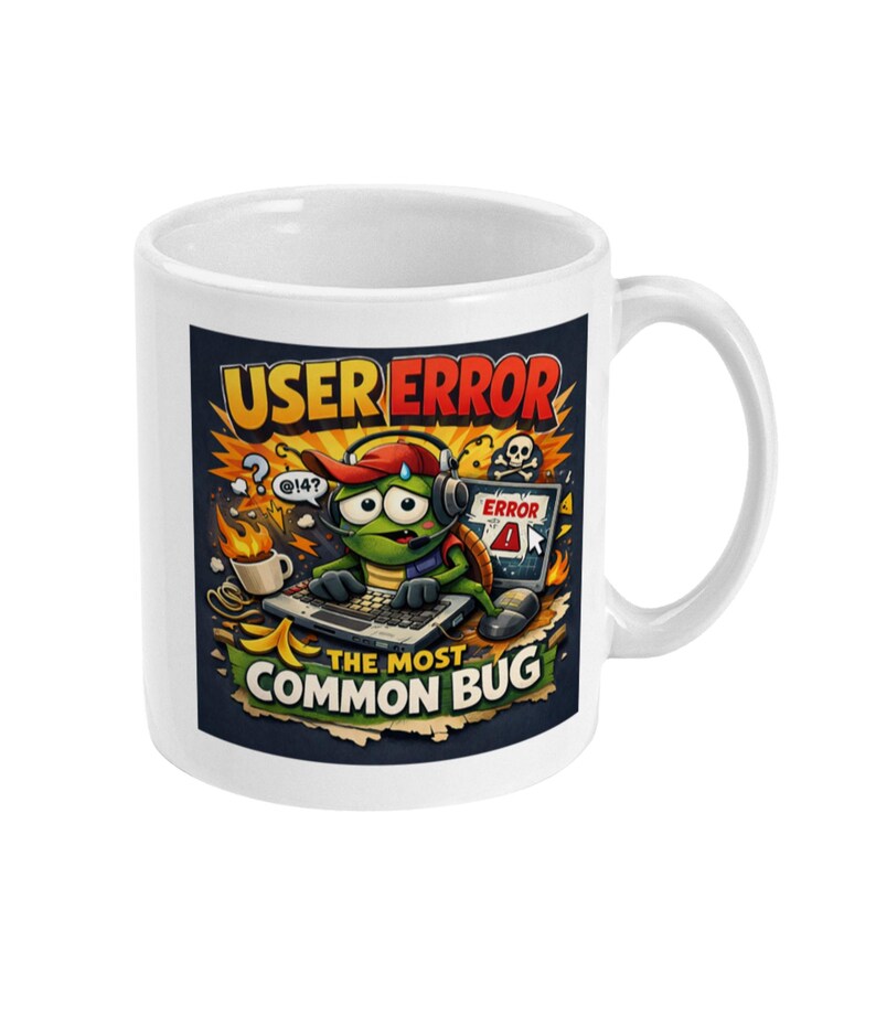 May include: White ceramic mug featuring a cartoon turtle wearing headphones and a hat, typing on a keyboard. The mug has the text "USER ERROR" and "THE MOST COMMON BUG" with other graphics.