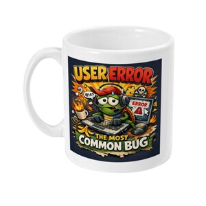 May include: White ceramic mug with a colorful cartoon design. The design features a turtle wearing a headset and hat, working on a laptop with the text "USER ERROR" and "THE MOST COMMON BUG". A skull and error message are also included.