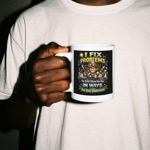 May include: White ceramic mug with a colorful graphic that reads "I Fix Problems" with a cartoon image of a repairman. The mug also has the text "You Didn't Know You Had, In Ways You Don't Understand."