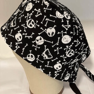 May include: Black and white scrub hat with a repeating pattern of Jack Skellington's face and crossbones.