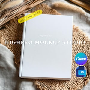 Può includere: Un mockup di libro bianco vuoto su una superficie di juta marrone con uno sfondo in tessuto bianco. Il libro è pronto per il tuo design. Preparato da Highpro Mockup Studio.
