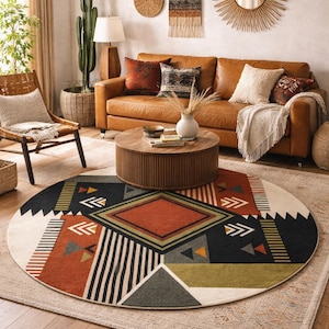 May include: A round area rug with a geometric design. The rug features a central diamond shape in rust, surrounded by black, white, and green geometric patterns. The rug is placed on a light beige rug and hardwood floor.