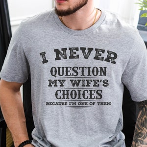 May include: A gray t-shirt with the text "I never question my wife's choices because I'm one of them".