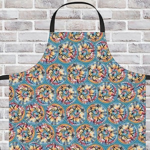 May include: A colorful apron with a repeating pattern of dancing bears in tie-dye circles on a teal background. The apron has black straps and a neck loop, perfect for cooking or crafting.